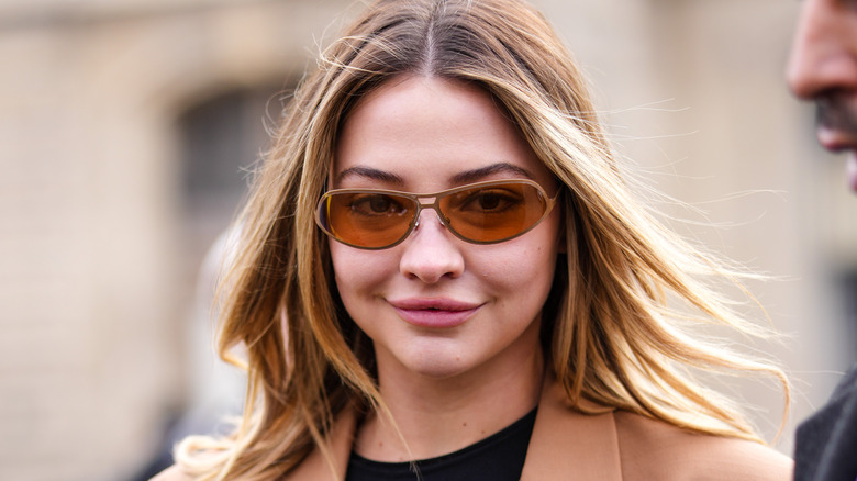 Madelyn Cline smiling with oval sunglasses