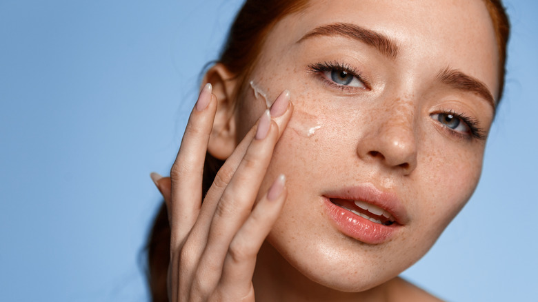 Woman applying product to cheek