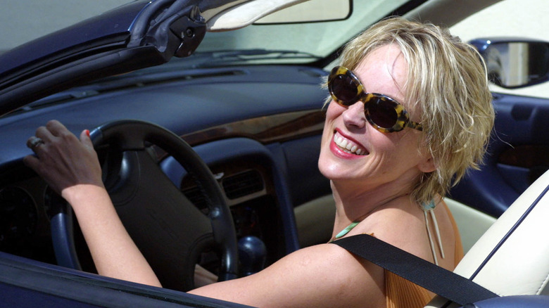 Sharon Stone smiling behind the wheel of a car in 2001