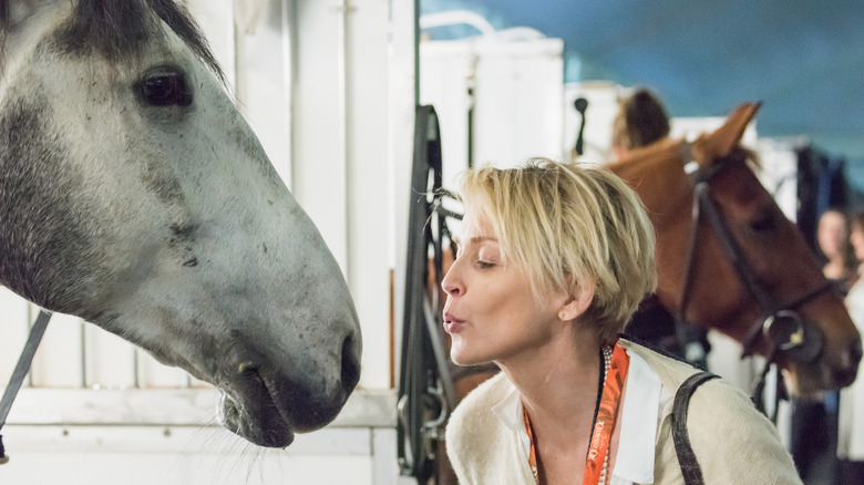Sharon Stone interacting with a horse in 2016