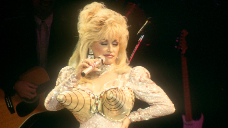 Dolly Parton performing on stage in a cone bra
