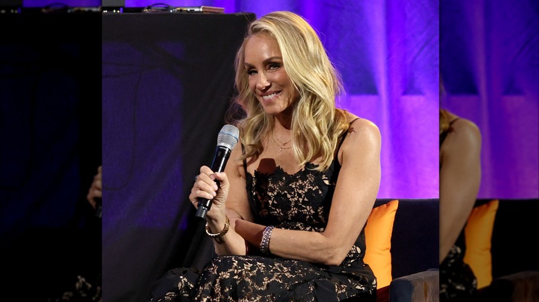 Tracy Pollan smiling and holding a microphone