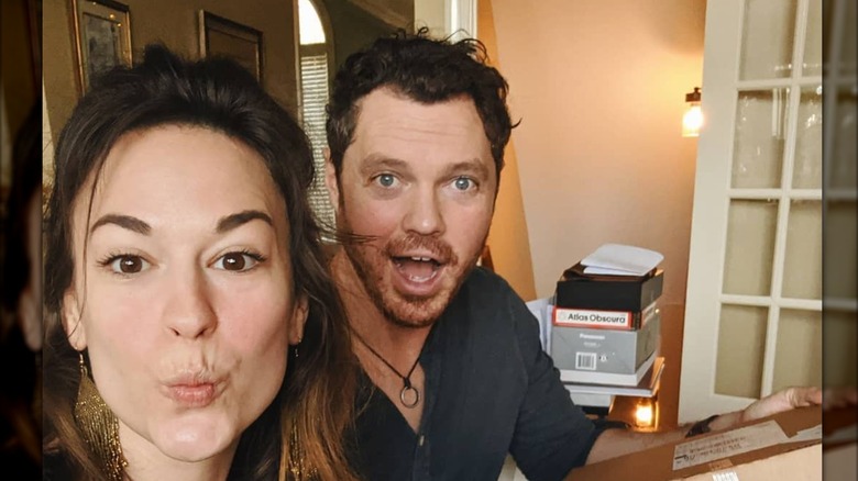 Rachel Hendrix and Daniel Stine taking a selfie in front of their desk