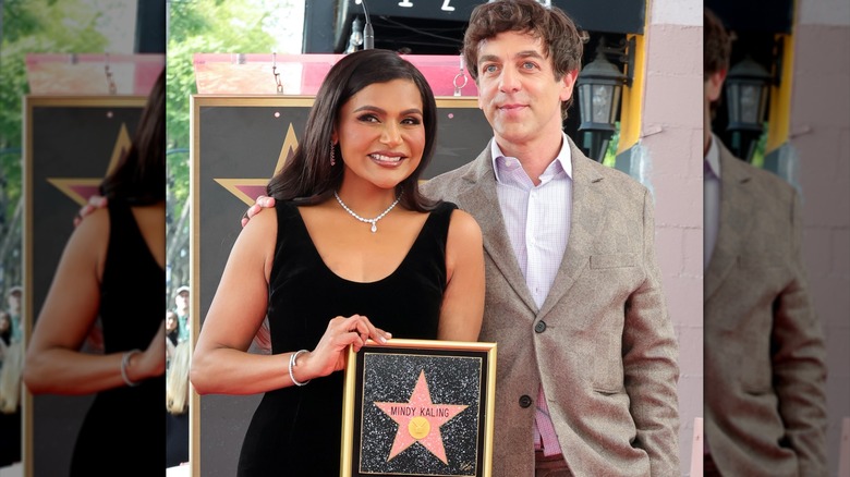 Mindy Kaling holding a picture of her star on the Walk of Fame next to BJ Novak who is holding her shoulder.