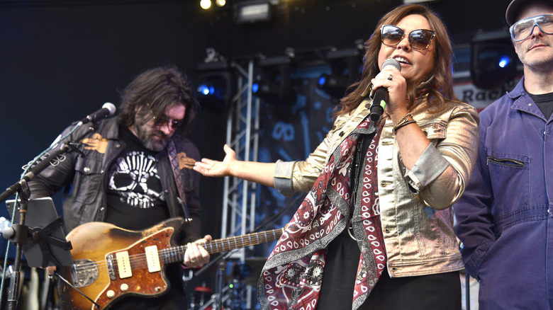 John M. Cusimano holding a guitar while Rachael Ray speaks into a microphone