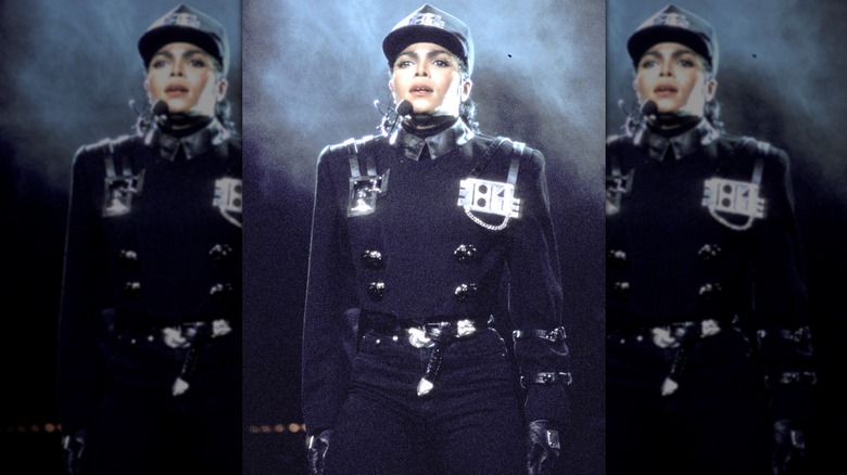 Janet Jackson singing and raising her arms to her sides