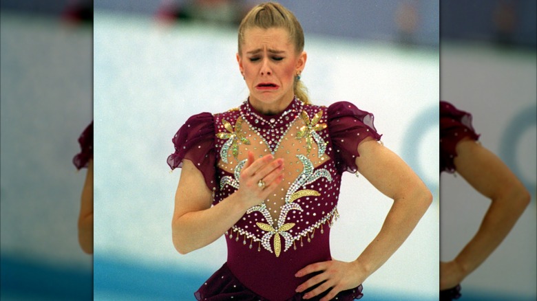 Tonya Harding crying on the ice in maroon skating dress with gold and silver embellishments