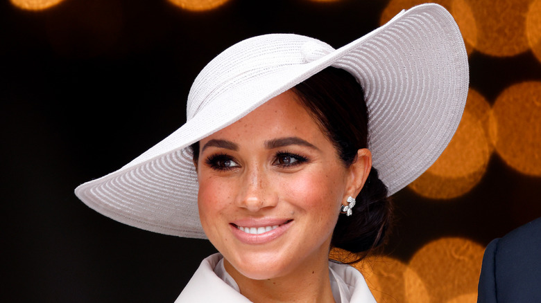 Smiling Meghan Markle wearing a wide-brimmed hat at the 2022 National Service of Thanksgiving.