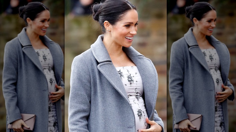 Meghan Markle wearing a floral green dress and a black blazer over top.