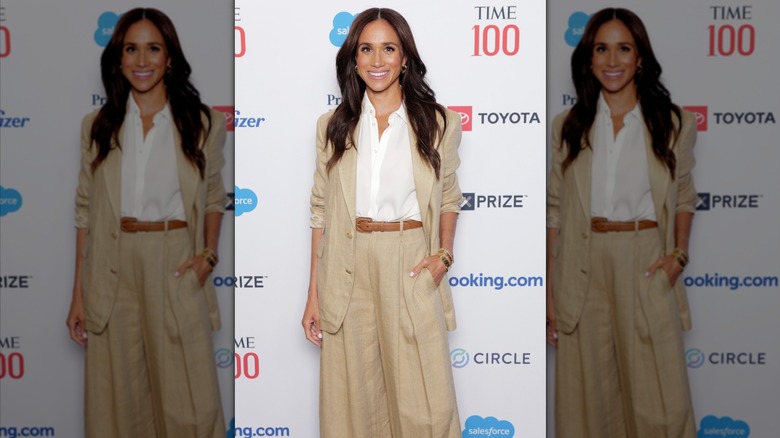 Meghan Markle wearing a tan suit from Ralph Lauren and a white shirt at the Time 100 red carpet.