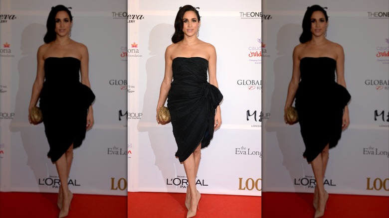 Meghan Markle wearing a strapless black dress and holding a gold clutch to a Global Gift Gala in London in 2013.