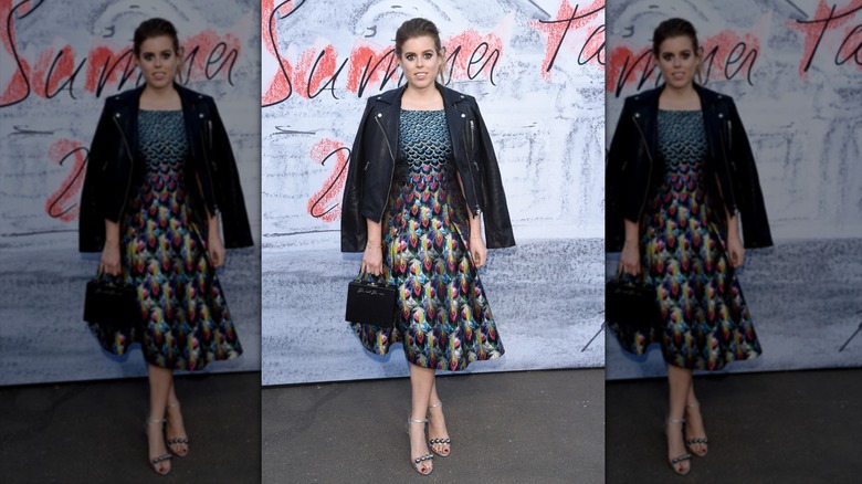Princess Beatrice posing in a peacock-print dress and leather jacket