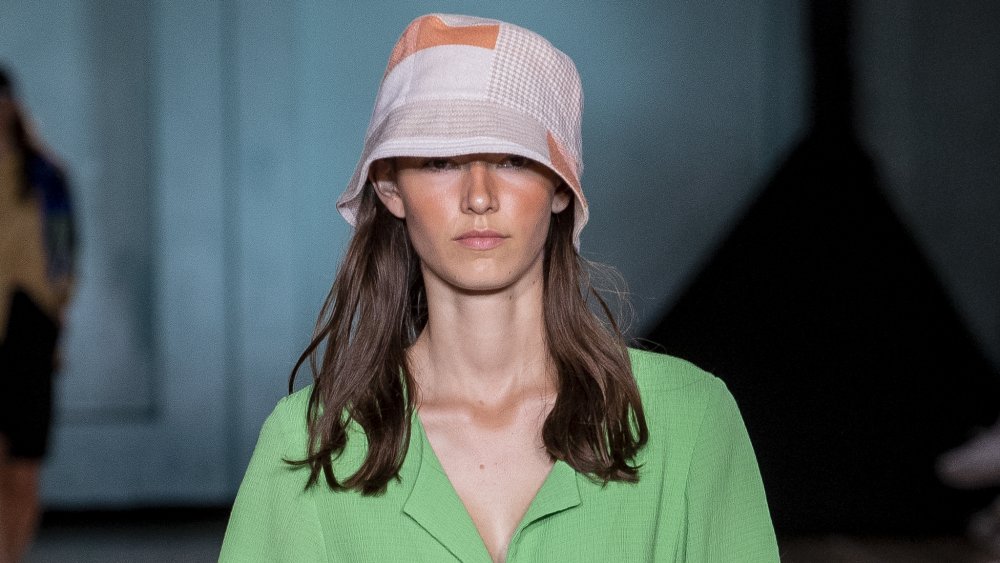 model wearing a patchwork bucket hat, two fashion trends that aren't worth the money