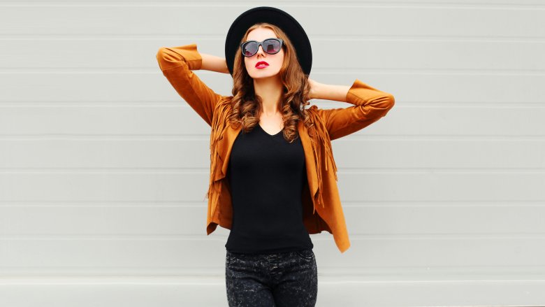 Fashion trends woman in leather fringe coat and big  sunglasses