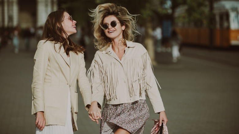 Women laughing and holding hands