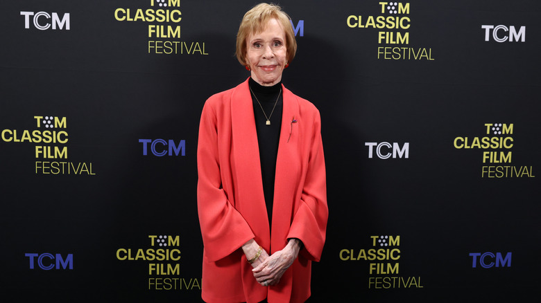 Carol Burnett wearing a red jacket over a black top