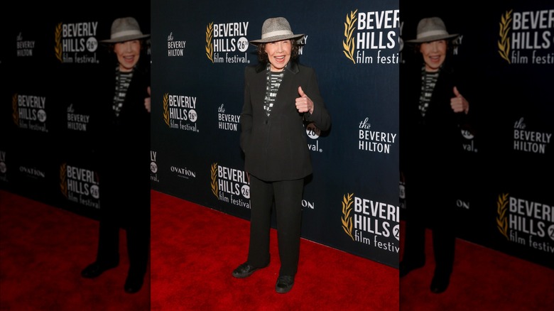 Lily Tomlin wearing a grey hat and pantsuit at a film festival in 2026
