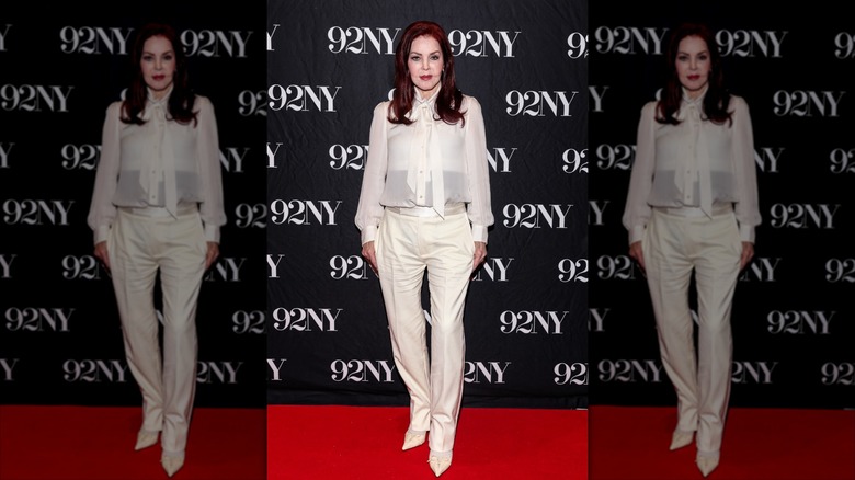 Priscilla Presley posing in an all-white look while promoting her memoir in 2025