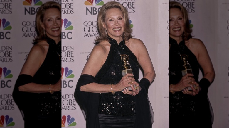 Faye Dunaway smiling and holding a golden globe