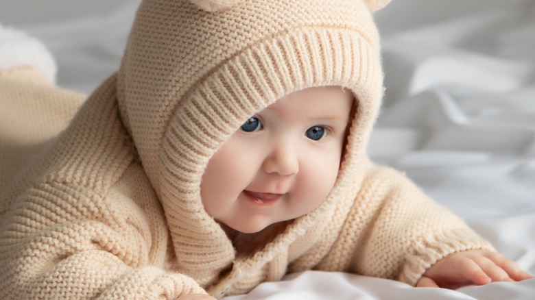 Premium Ai Image A Baby Is Smiling And Sitting On A Blanket With
