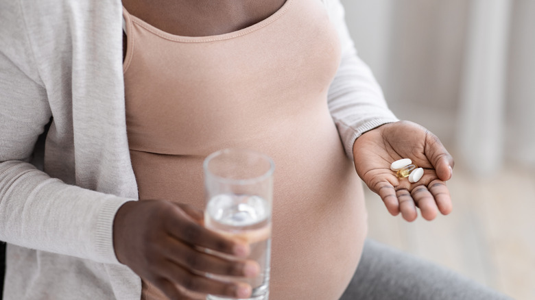 pregnant woman taking a pill