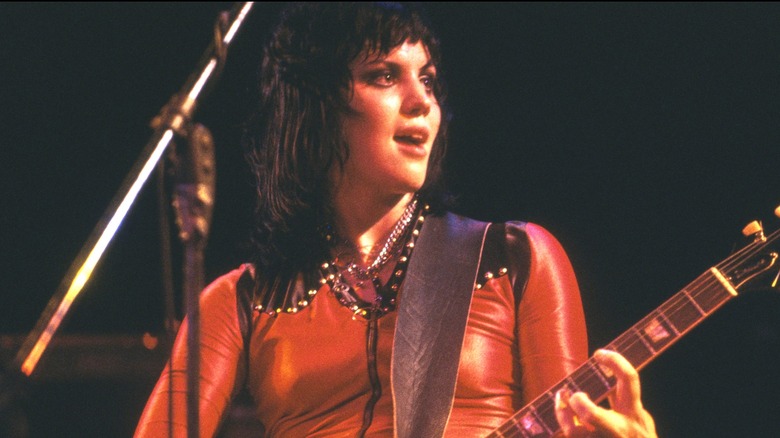 Joan Jett playing guitar on stage in 1977