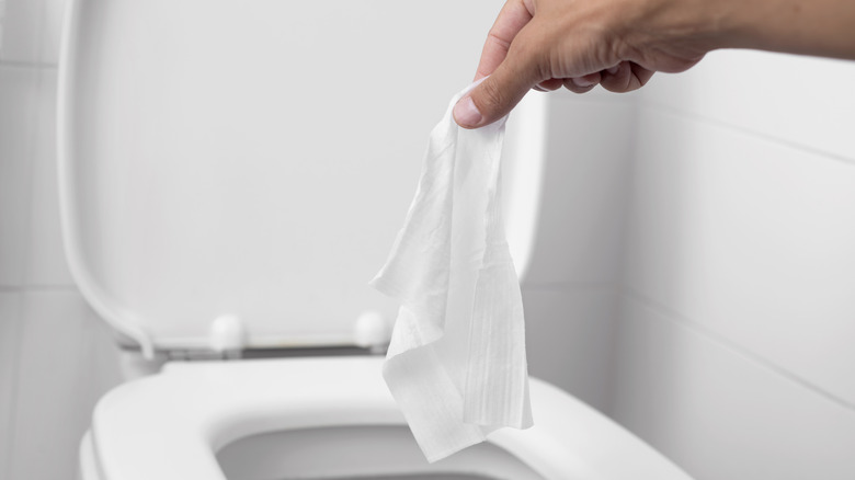 A wipe being thrown into the toilet 