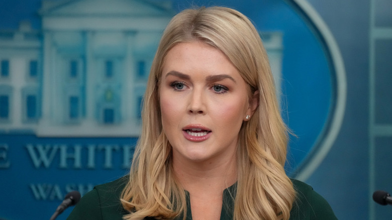 Karoline Leavitt speaking at a White House press briefing while wearing a green shirt.