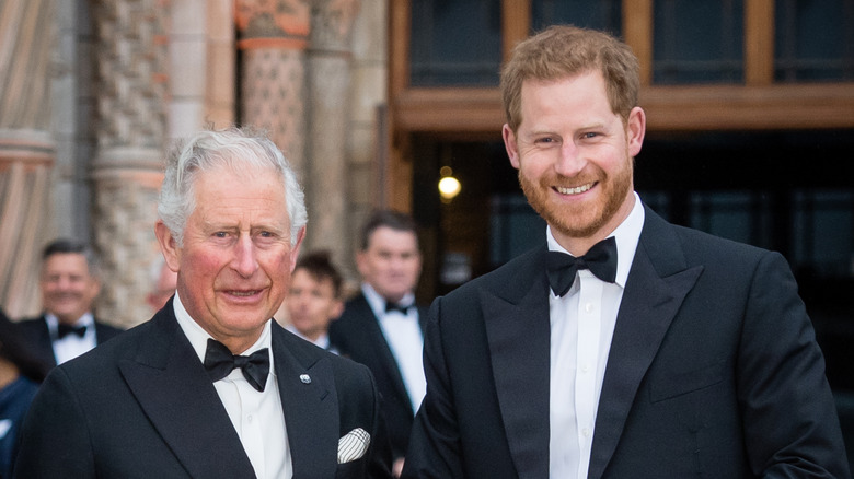 King Charles III and Prince Harry smiling