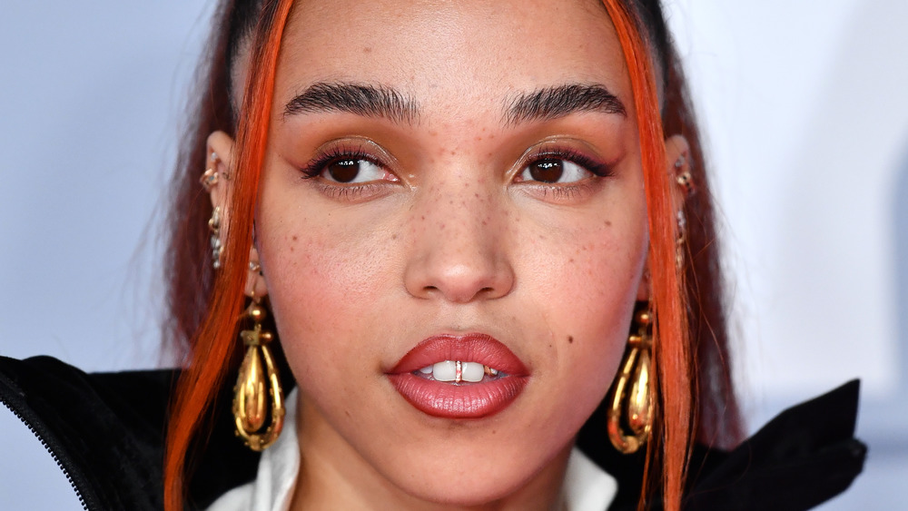 FKA Twigs looking serious with gold earrings