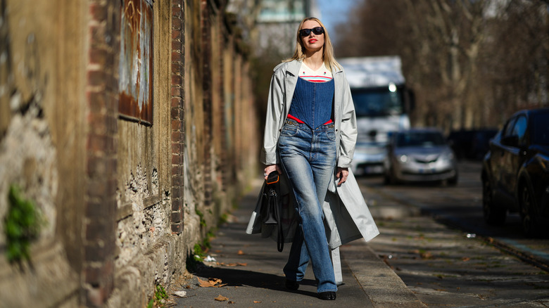 Woman in flared jeans and trench