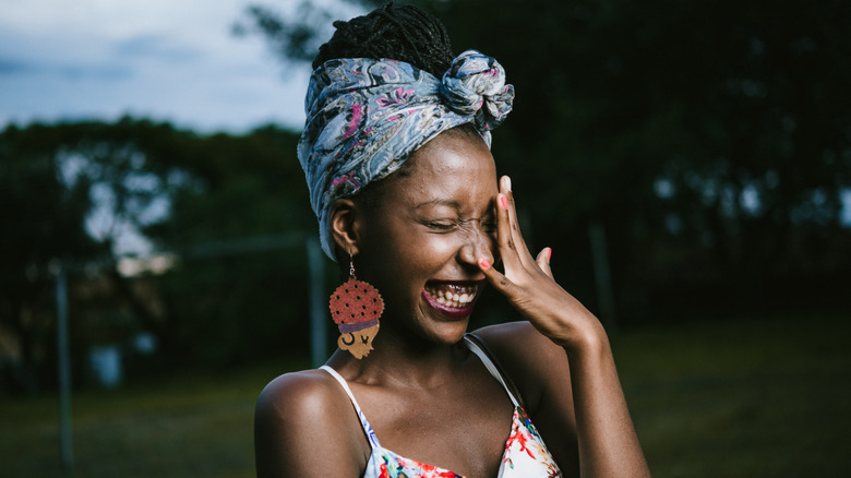 Shy woman laughing and covering face