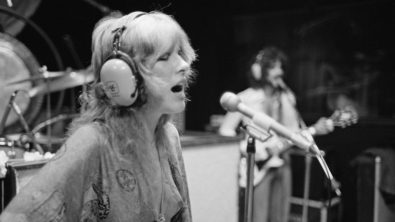 Stevie Nicks singing with headphones on.