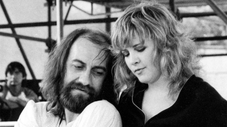 Stevie Nicks and Mick Fleetwood bringing their faces close together.