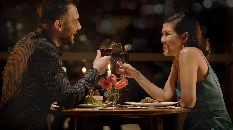 couple cheersing wine glasses on date