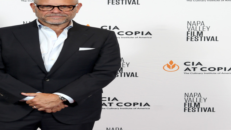 Alton Brown posing in front of a white background at the Napa Valley Film Festival