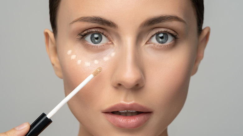 Woman applying concealer