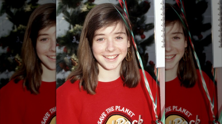 Alyson Hannigan (in a red sweater) posing for a photo in 1989