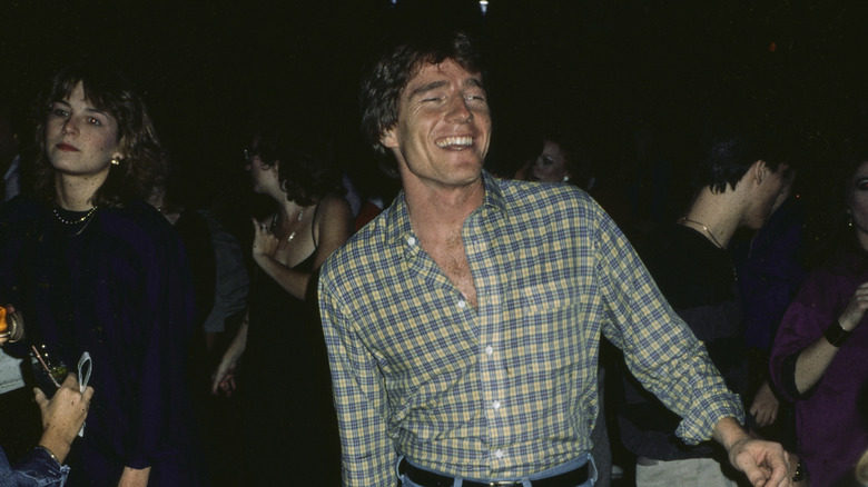 Bryan Cranston (wearing a plaid long-sleeve shirt) dancing at a party in 1984