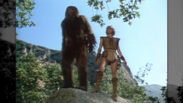 Bigfoot and Wildboy standing atop a rock.