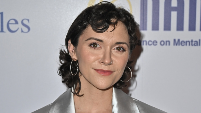 Alyson Stoner posing on red carpet with hoop earrings
