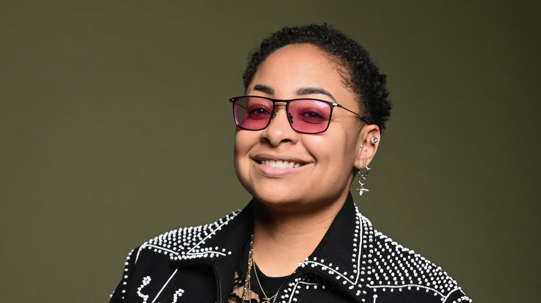 Raven-Symoné smiling and wearing pink glasses