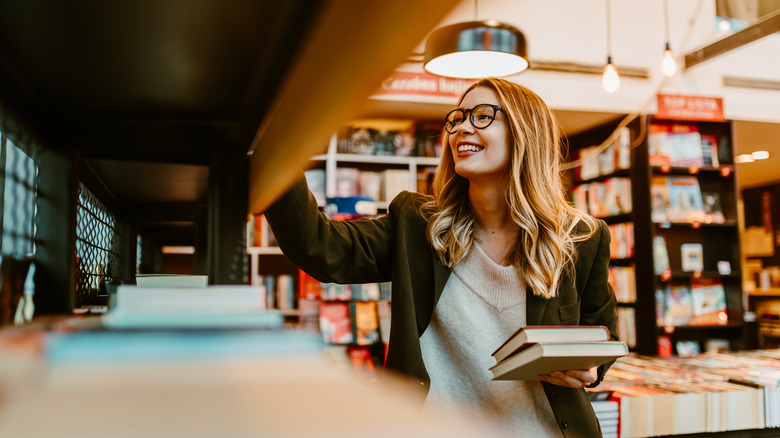 woman looking happily at shelves of books