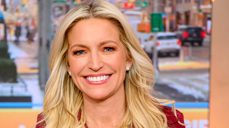 Ainsley Earhardt smiling in a red dress in studio