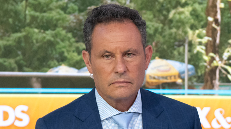 Brian Kilmeade sitting down while wearing a blue suit at Fox and Friends.