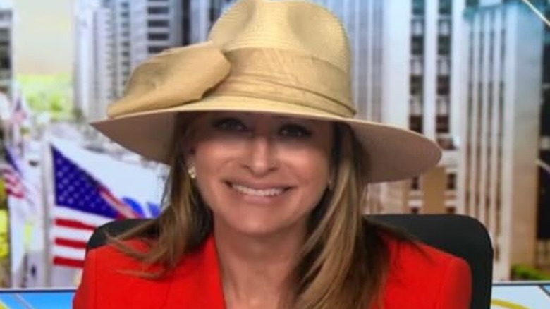 Maria Bartiromo at a news desk with a cream colored hat.