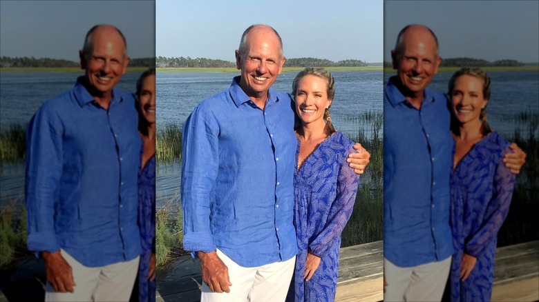 Dana Perino and Peter McMahon smiling while posing together in blue outfits