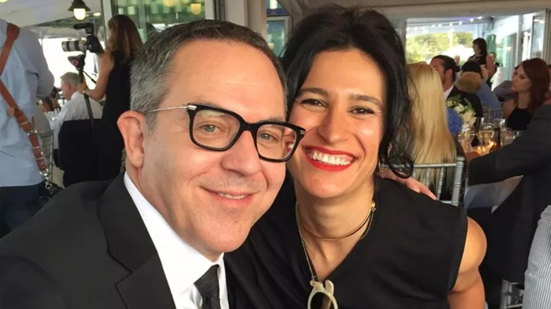 Greg Gutfeld and Elena Moussa smiling while cuddling up at an event