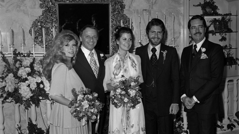Tina Sinatra smiling and holding a boquet of flowers on her wedding day to Wes Farrell in black and white.