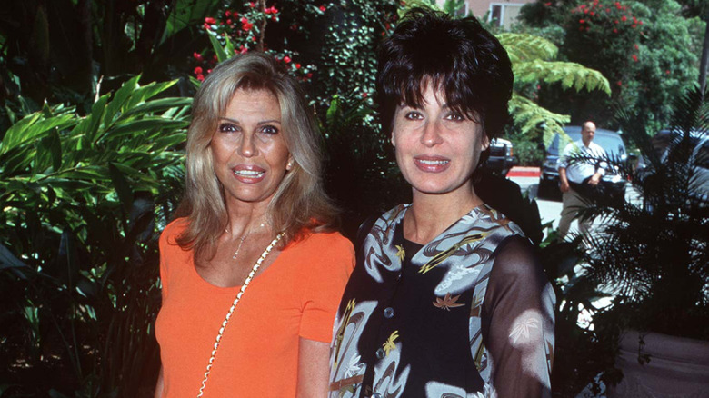 Nancy Sinatra and her sister Tina Sinatra smiling outside.